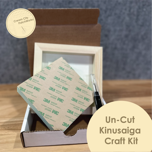 Un-Cut Kinusaiga Craft Kit with materials and tools on a wooden surface.